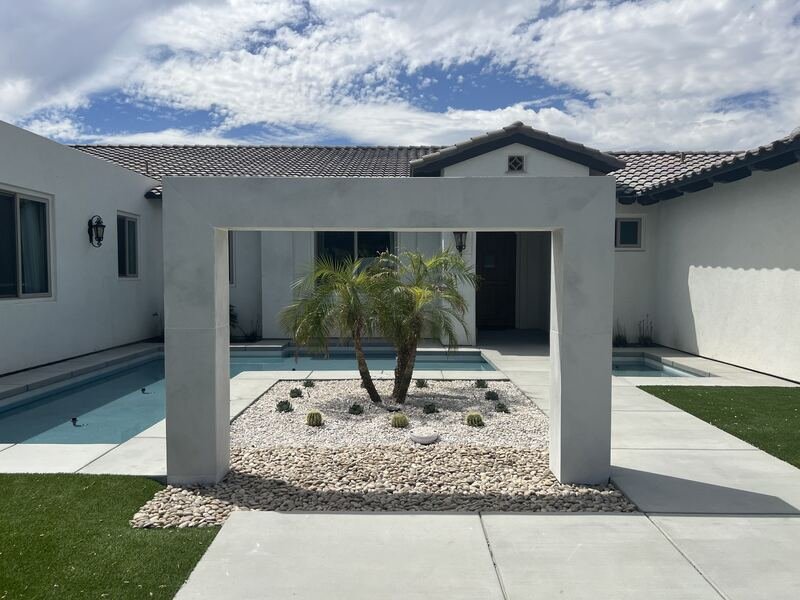 Concrete portal framing pygmy date palms in white rock