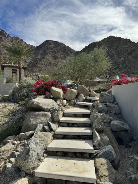 Wide stone steps set into a boulder hillside leading toward mountains