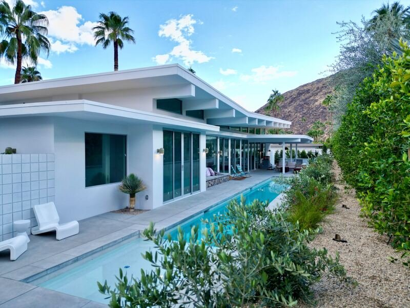 Desert planting and gravel along the edge of a mid-century pool